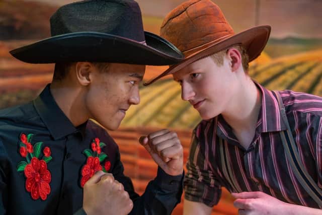 Getting ready to fight in a scene from 'Oklahoma' are Josh Gwaje (Curly) and Ryan Ford (Jud Fry).