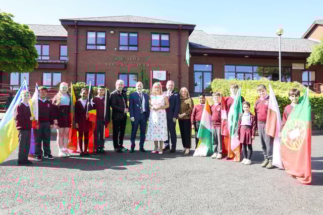 Pupils welcomed the First Minister in ten different languages and bore the flag of their home nation. Photo: submitted