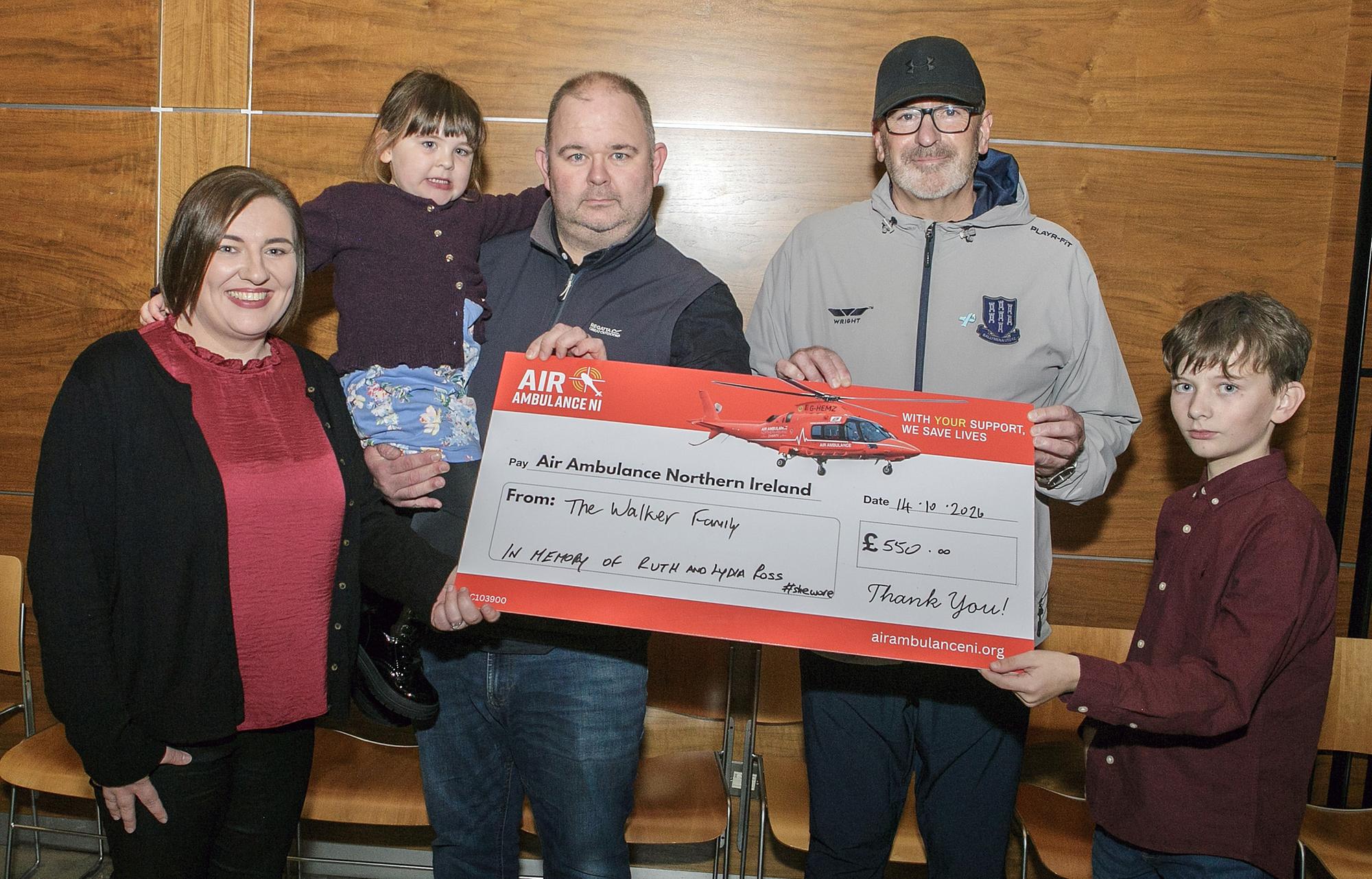 Band member, Paul Ross, pictured receiving a cheque for £550 from the Walker family, Alan, Kendal, George and Beth. The money was raised at Alan's 40th birthday and will go towards Air Ambulance in memory of Paul's late wife Ruth and daughter Lydia.
