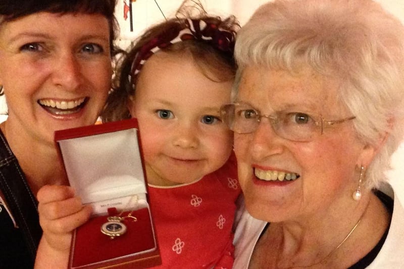 Pat Crossley pictured with her daughter Adrienne and grand daughter Niamh and her RNLI service award