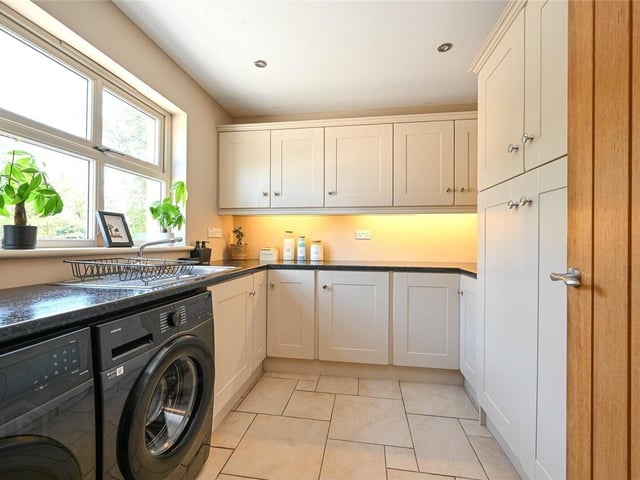 Utility room fitted with high- and low-level units and plumbed for a washing machine and tumble dryer.