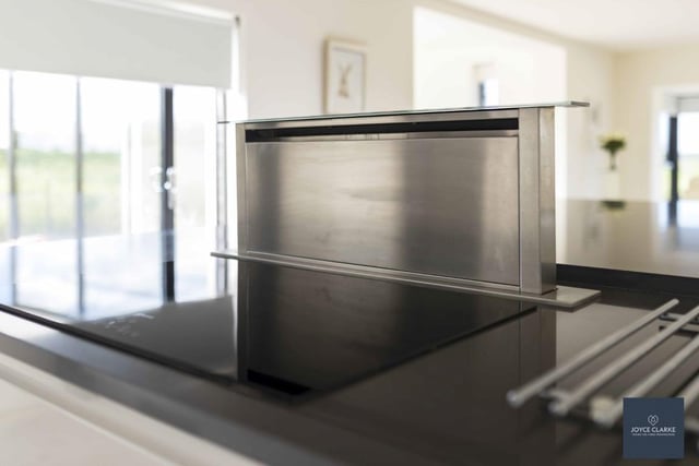 The kitchen features a Schott ceran induction hob with touch operated recessed down draft extractor