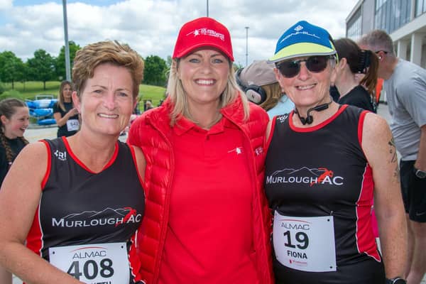 Colleen Milligan, centre, business development manager for Air Ambulance Northern Ireland catches up with Gweneth Rogan, left, and Fiona Barr before Saturday's  Almac charity Fun Run. PT22-237.