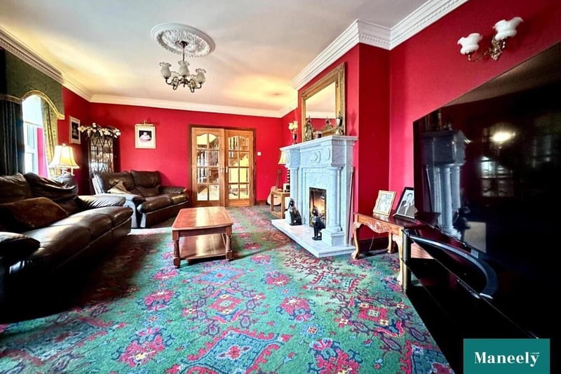 Carpeted family room with French doors from entrance hall, and gas fire with marble fireplace surround.