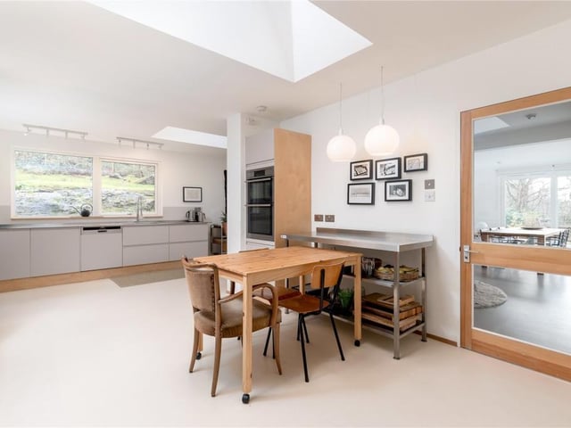 The fitted L-shaped kitchen/breakfasting room is in a stylish, minimalist design with a wide range of freestanding base mounted units and integrated hob and ovens.