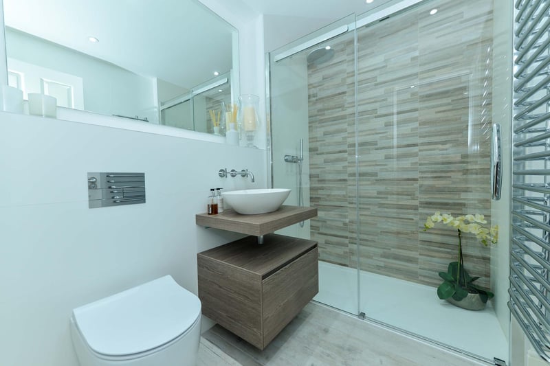 Shower room with double walk-in shower cubicle with wall mounted thermostatically controlled drench shower head and hypoallergenic anti slip shower tray, wall hung vanity unit, and floating wall hung WC.