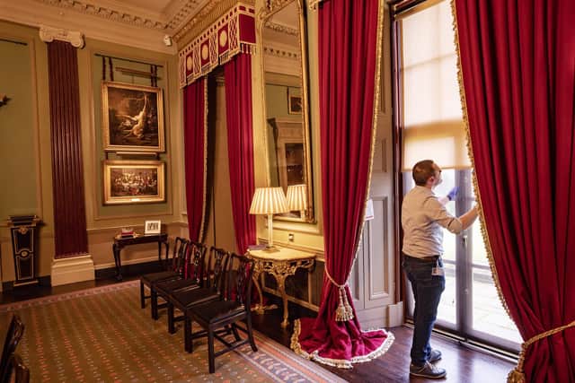 The State Dining Room, showing David Orr (Castle and Collections Manager) examining the window blinds. © Historic Royal Palaces