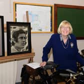 Chief organiser Joan Crawford posing beside photos of her favourite rider Gaicomo (Ago) Agostini supplied by Cecil Smith