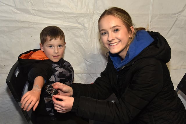 Kayson Thompson (6) shows off his glitter tattoo which was applied by Lucy Maxwell of Friendly Faces at the Christmas lights switch on at the Legahory Centre, Craigavon on Wednesday. PT49-212.