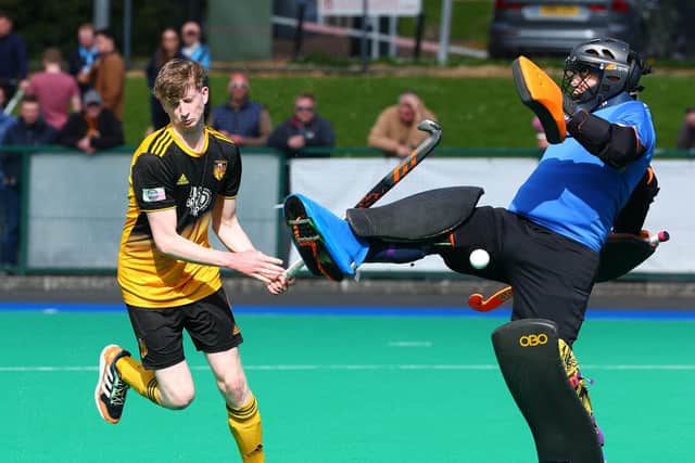 Adam Scott tries to sneak the ball past the onrushing Saintfield goalkeeper