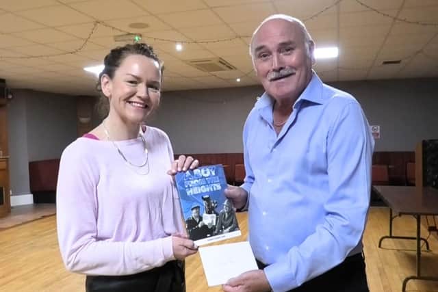 Robert Ramsey presents Lisa Bailey from Cancer Research with a four figure sum - £2 from every book sold was pledged to the charity. Credit Robert Ramsey
