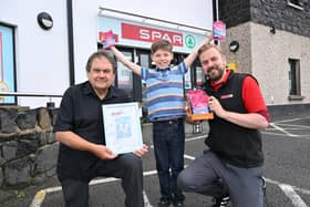 Chris and Graham Todd with Archie Barr and his ‘Wobbly Jelly’ monster drawing which has inspired the packaging design of new confectionary product, Fizzy Fangs. Photo submitted.