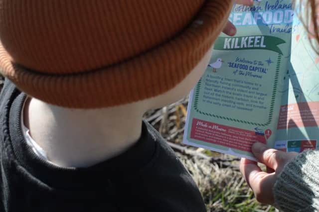A seafood adventurer using a trail map to explore the busy harbour town of Kilkeel