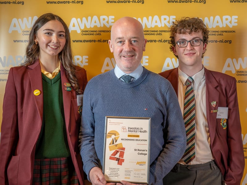 A member of staff and students from St Ronan's College in Lurgan collect their award after the school was recognised for their dedication to promoting positive mental health. The school has integrated AWARE NI’s mental health programmes such as Mood Matters Young People into their curriculum and also maintained a consistent focus on mental health through initiatives like signposting, appointing mental health champions and creating dedicated mental health spaces, including a gardening project.