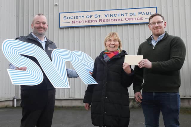 Mark McMullan and Stephen McQuillan of McQuillan Companies present Pauline Brown, SVP Regional Manager, with a donation for the vital work of SVP