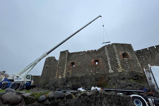 One of the cannons being lifted by crane over the curtain wall of the castle on July 21. Photo: DfC
