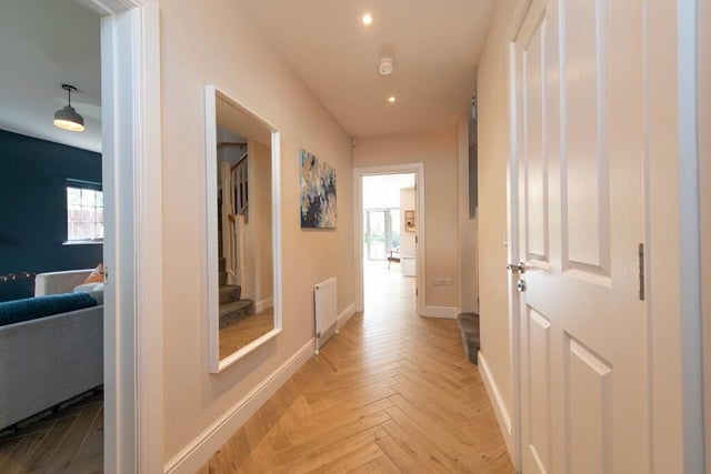 Hallway with parquet tiled flooring.