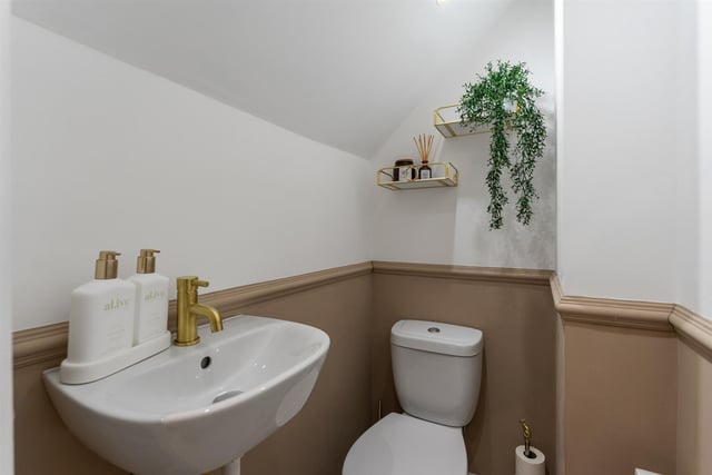 Furnished cloakroom with contemporary, white, two piece suite comprising wash hand basin and WC.