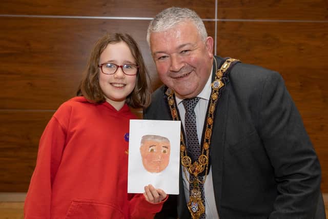 The Mayor of Causeway Coast and Glens Borough Council Councillor Ivor Wallace pictured with Evie Nicholl who painted this impressive portrait of the Mayor.