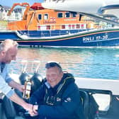 Richard Connor of the Causeway Lass presents Geoff Holt with a bottle of Bushmills to welcome him to Portrush. Credit Alan Simpson