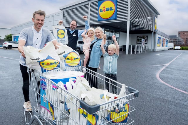 Simon Magowan, store manager, Lidl Carrickergus, congratulates David Long and family after the two-minute challenge.