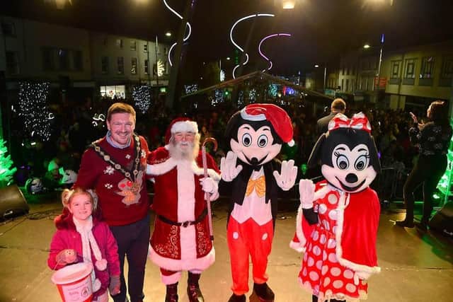 Pictured at the 2022 Christmas switch-on in Lisburn are Mayor Councillor Scott Carson and his daughter with Santa, Mickey and Minnie Mouse on the stage. Picture: LCCC