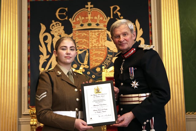 Carrickfergus teenager Kaitlyn Beggs was appointed to the role of His Majesty’s Lord Lieutenant’s Cadet for the County of Antrim while Colour Sergeant Mark Kitchen, Sergeant mark Hoban and Lance Corporal David Whiteside, all from Carrick, were each awarded the Lord Lieutenant’s Certificate for Outstanding Meritorious Service Above and Beyond The Call of Duty, one of the highest accolades that can be conferred on members of the Reserve Forces and Cadet movement.
Kaitlyn, an enthusiastic Cadet Corporal with her local Carrickfergus Open Detachment Army Cadet Force, is one of twelve Lord Lieutenants’ Cadets appointed across Northern Ireland. The year-long post is largely ceremonial and Kaitlyn can expect a busy year ahead as she accompanies Mr David McCorkell, His Majesty’s Lord Lieutenant for the County of Antrim, on major civic occasions.  In recognition of her appointment, Kaitlyn will be entitled to wear a special insignia on her cadet uniform. Kaitlyn is pictured receiving the certificate which marks her appointment from Mr David McCorkell, His Majesty’s Lord Lieutenant for the County of Antrim.