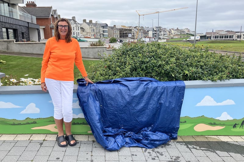 Owner Maureen Davidson beside the final mystery panel of the golfing greats mural which had the whole town talking about which golfer would be added to the gallery.