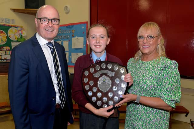 Maisie Millar, top prize winner at Ballyoran Primary School prize day, receives her trophy for her outstanding contribution to school life from principal, Richard Woolsey and special guest, former teacher, Aine McCreesh-West. PT23-248. Photo by Tony Hendron