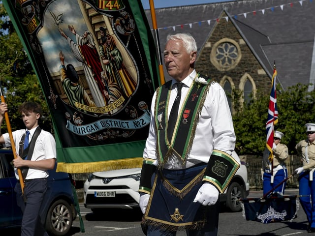 Standards are lowered as they pass by the war memorial in Lurgan during the RBI 13th parade.