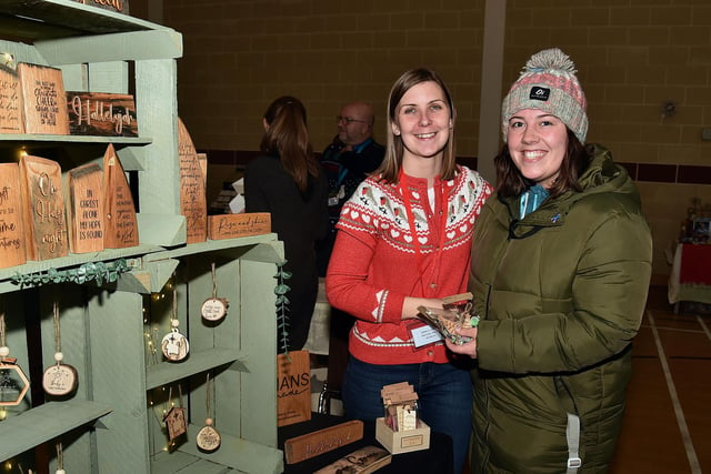 Sara Robinson, left, shows off some of her laser-engraved products to Hannah Daly at the Shankill Parish Christmas Market on Saturday. LM50-213.