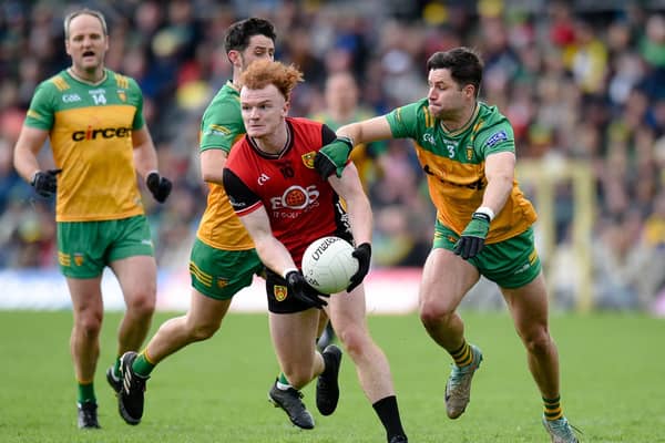Danny Magill gets a pass away despite a tackle from fullback Brendan McCole when Down played Donegal in the Ulster semi-final. Pics: Brendan Monaghan