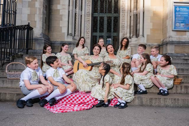 Anna Maria Boyle (with guitar) and Hannah Russell (singing) with all the young people sharing the roles of the Von Trapp Children. Pic credit: Belfast Operatic