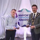 Ben Annett from Brooklands Youth Centre is pictured with his two Awards: the Brian McDowell Volunteer of the Year Award and the Mayor's Choice Award presented by Mayor, Councillor Scott Carson and Paul Clark.