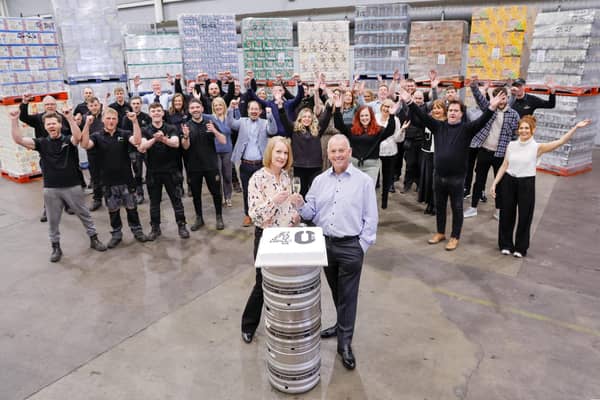 United Wines managing director Martin McAuley and sales administrator Helena Smith celebrate 40 years of success in Northern Ireland with staff at the company’s warehouse in Craigavon. Picture: Philip Magowan