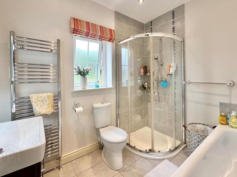 Family bathroom with corner shower and separate bath.