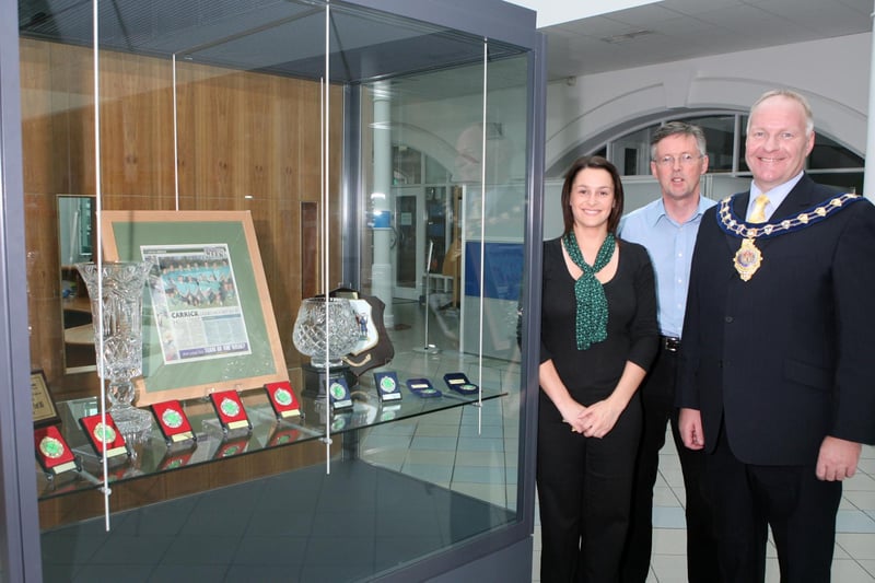 Pictured in 2007 at Carrick Ladies Hockey team's trophy display in Carrick Civic Centre are Christine Waide and Peter Stevenson with then Carrick Mayor David Hilditch . Ct22-004tc