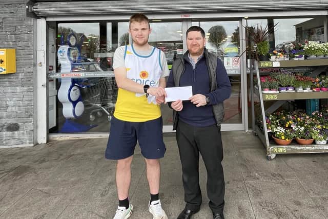 Conor Doherty is presented with sponsorship for his running shoes by Paul McArdle, manager of Campbell’s Eurospar, Scarva Street.