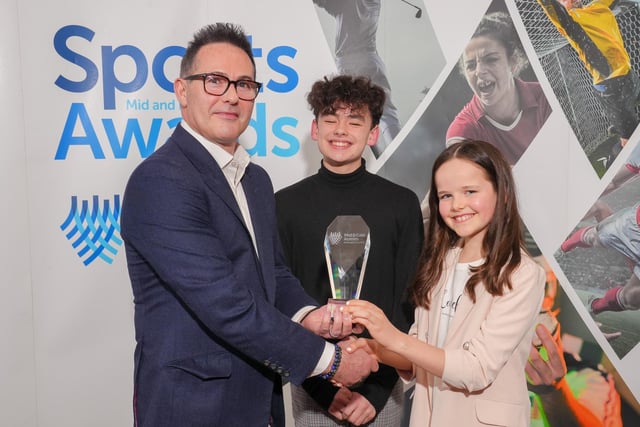 Glen Stewart from McCadden presents the Team of the Year award to Emily McClune and Oliver Wilkinson.