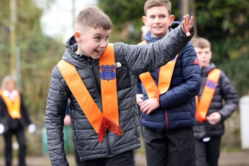 A young member of Ballycastle District Junior LOL No.8 waves to a well wisher during the Junior Orange parade in Ballymoney.