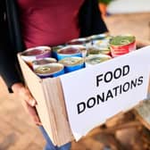 Close-up of a young woman standing outside with a box of food donations for a charitable cause. Credit: AJ Watt Getty Images