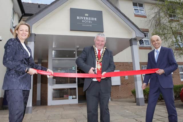 Causeway Coast and Glens Council Mayor Cllr Ivor Wallace has the honour of cutting the ribbon at the official opening of the Riverside Hotel Coleraine pictured with Karen Yates CEO Causeway Chamber of Commerce along with Rajesh Rana, director of the Andras House Hotel Group