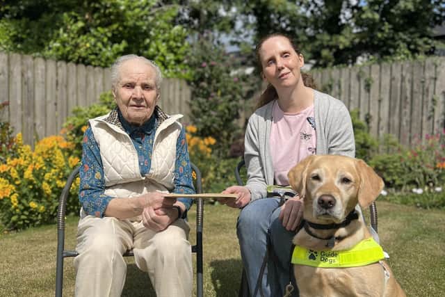Mirzda Oak, who celebrated her 100th Birthday handing over a donation to guide dog partnership Jo Toner and Emba. Pic Credit: Guide Dogs NI