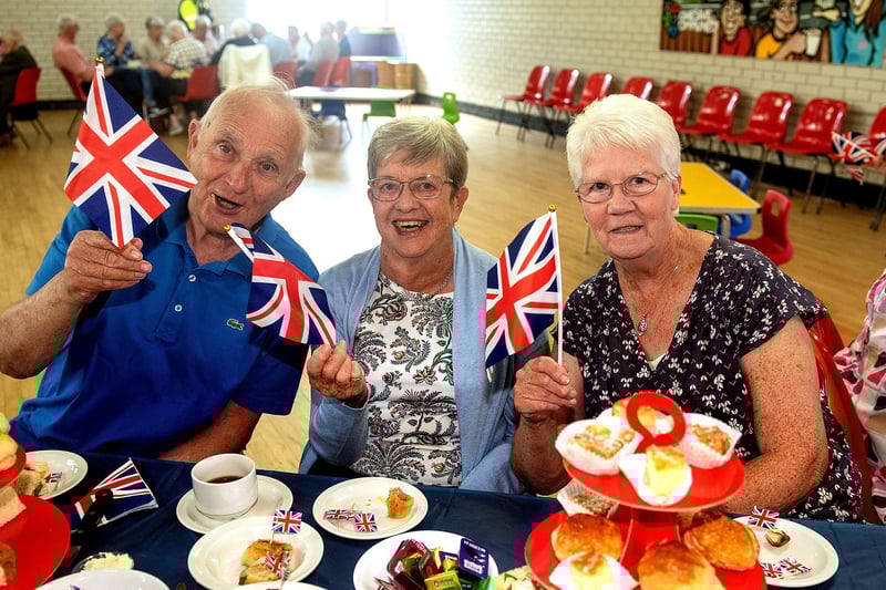 Waving their flags at the tea party are from left, Leslie and Winnie Wylie and Olive Richards. LM19-203.