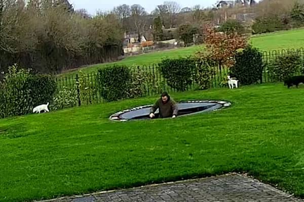 Charlie Bond hits the water after plummeting through the trampoline