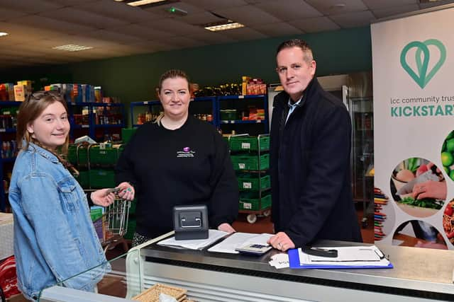 Lynsey Agnew, CEO of Lisburn Community Trust, and volunteer Rebecca Starritt (left) explain to Ciaran Stitt, Housing Executive, how Kickstart Social Supermarket helps vulnerable customers at risk of tenancy breakdown. Pic credit: NIHE