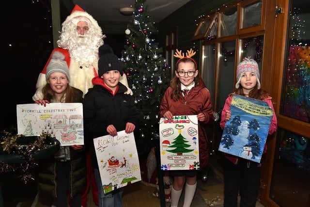 The winners of the Hardy Primary School P7 poster competition whose prize was to switch on the Richhill Christmas lights. Posing with Santa are from left, Ruby Jennett, Carter Gillaners, Maisie Willis and Kirstie Purdy. PT49-250.