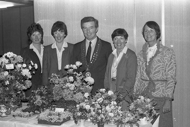 Competitors Mrs Sandra Forshaw, Mrs Elizabeth Dickey and Mrs Rita Boyd show some of the floral displays in the annual Rotary Club Show to president Jack Megarry and his wife Sandra, second from right, in September 1982