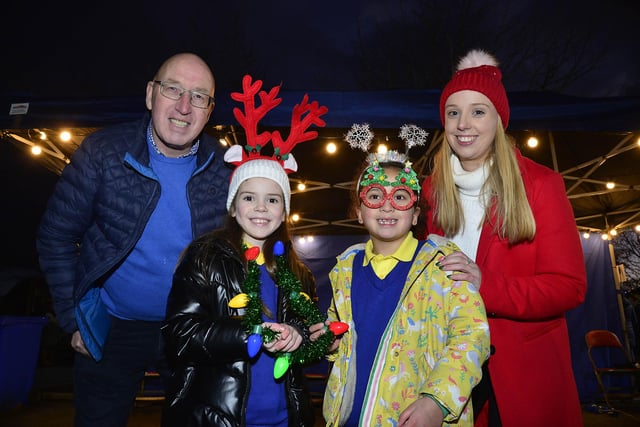 Councillor John Laverty BEM with teacher Amy Murphy and school children, Emily Marner and Shyla Shahi at the Carryduff Christmas Market
