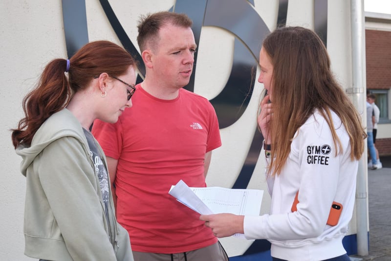 Niamh Campbell and Olivia Eastwood chat with teacher Mr Elliott after they received their GCSE results at Sperrin Integrated College, Magherafelt.